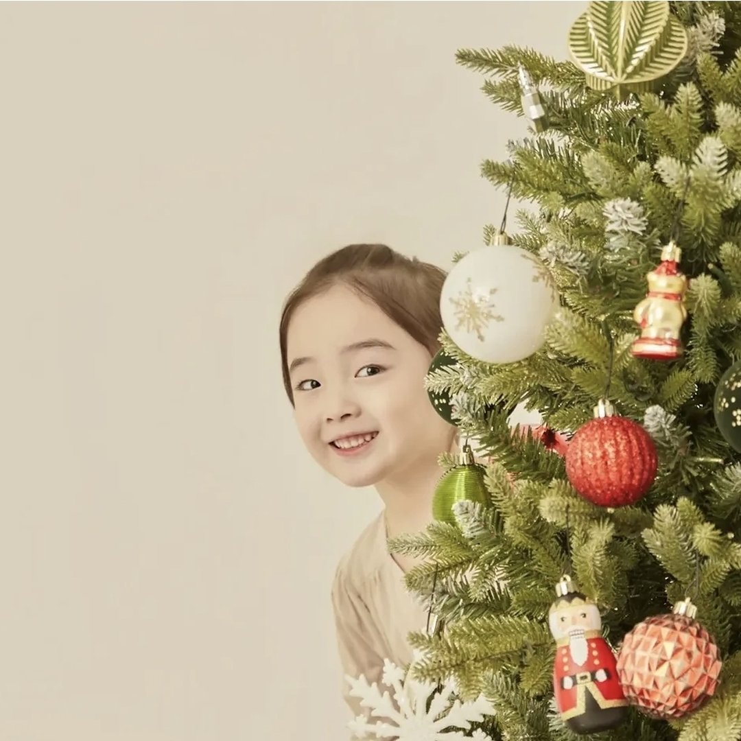크리스마스 트리 뒤에서 웃는 아이 — 크리스마스 컨셉 사진